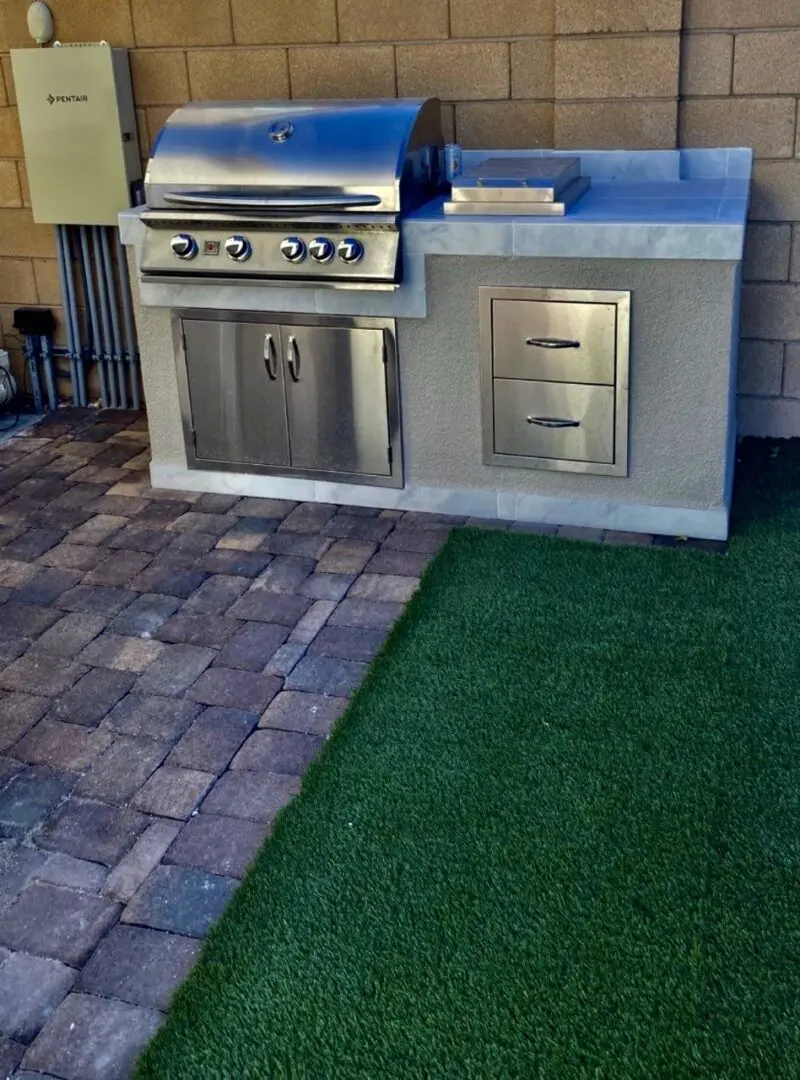 A grill and an oven on the grass.