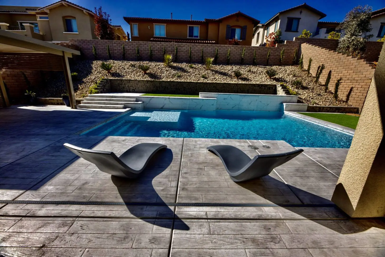 A pool with two chairs and a swimming pool.