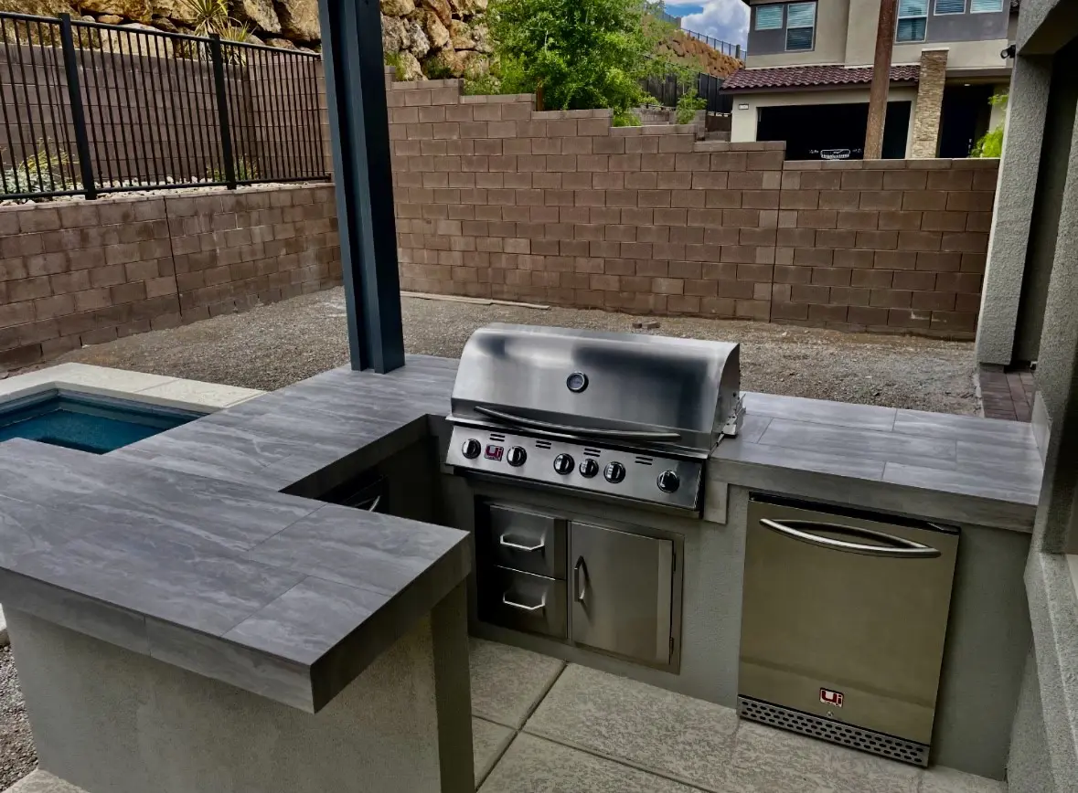 A grill and sink in an outdoor kitchen.
