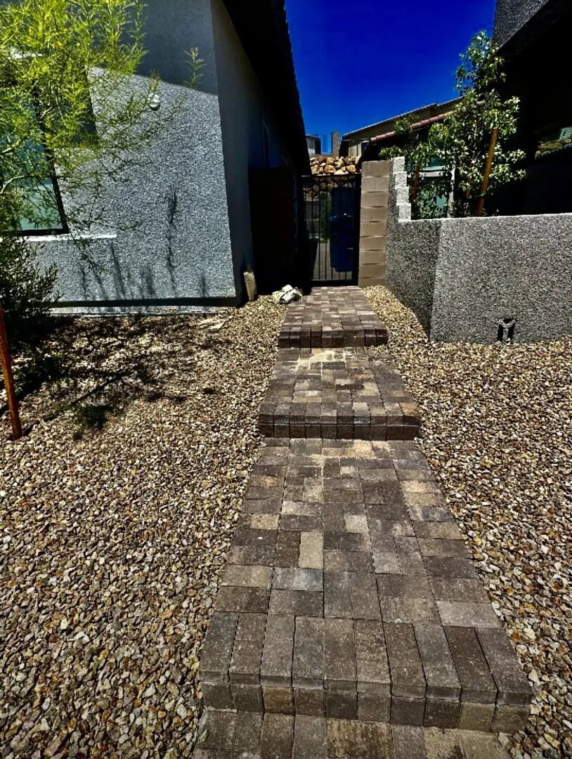 A walkway made of bricks in the middle of a yard.